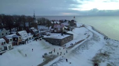 Kış boyunca Urk Hollanda deniz feneri karla kaplı kıyı şeridi, Hollanda 'da deniz feneri karlı kış havasında Urk manzarası