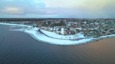 Kış boyunca Urk Hollanda deniz feneri karla kaplı kıyı şeridi, Hollanda 'da deniz feneri karlı kış havasında Urk manzarası