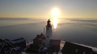 Kış boyunca Urk Hollanda deniz feneri karla kaplı kıyı şeridi, Hollanda 'da deniz feneri karlı kış havasında Urk manzarası