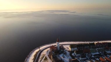 Kış boyunca Urk Hollanda deniz feneri karla kaplı kıyı şeridi, Hollanda 'da deniz feneri karlı kış havasında Urk manzarası