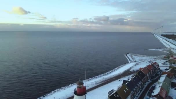 Urk Faro de los Países Bajos durante el invierno con la costa cubierta de nieve, vista de Urk en el faro nevado paisaje clima de invierno en Holanda — Vídeos de Stock