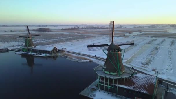 หมู่บ้านโรงปั่นลม Zaanse Schans ในฤดูหนาวที่มีภูมิทัศน์หิมะ, หิมะปกคลุมโรงปั่นลมประวัติศาสตร์ไม้ Zaanse Schans เนเธอร์แลนด์ฮอลแลนด์ — วีดีโอสต็อก