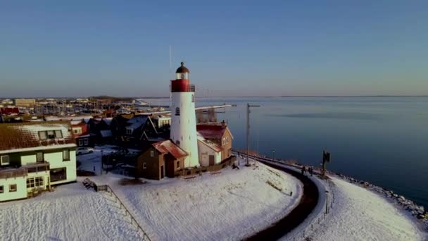 Kış boyunca Urk Hollanda deniz feneri karla kaplı kıyı şeridi, Hollanda 'da deniz feneri karlı kış havasında Urk manzarası — Stok video