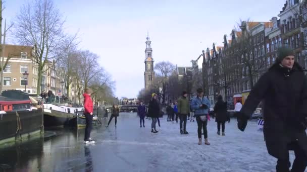 Schaatsen op de grachten in Amsterdam in de winter, bevroren grachten in Amsterdam in de winter — Stockvideo