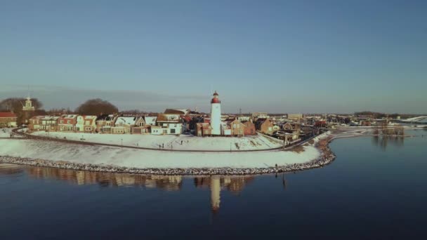 Kış boyunca Urk Hollanda deniz feneri karla kaplı kıyı şeridi, Hollanda 'da deniz feneri karlı kış havasında Urk manzarası — Stok video