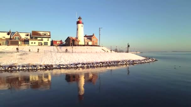 Kış boyunca Urk Hollanda deniz feneri karla kaplı kıyı şeridi, Hollanda 'da deniz feneri karlı kış havasında Urk manzarası — Stok video
