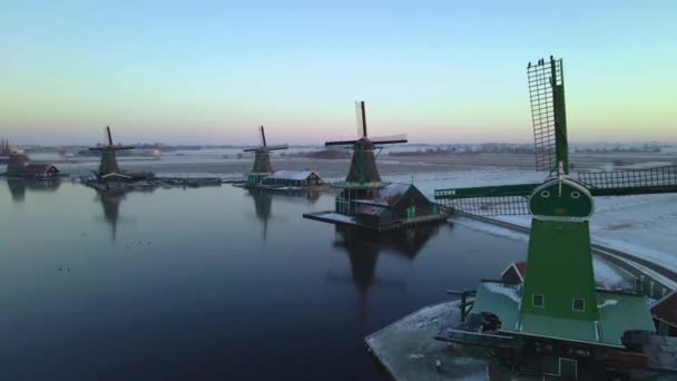 หมู่บ้านโรงปั่นลม Zaanse Schans ในฤดูหนาวที่มีภูมิทัศน์หิมะ, หิมะปกคลุมโรงปั่นลมประวัติศาสตร์ไม้ Zaanse Schans เนเธอร์แลนด์ฮอลแลนด์ — วีดีโอสต็อก