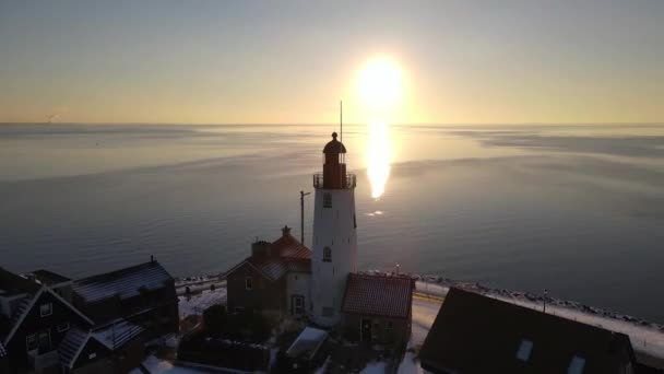 Urk Nederlandse vuurtoren tijdens de winter met besneeuwde kustlijn, Urk uitzicht op de vuurtoren besneeuwd landschap winterweer in Nederland — Stockvideo