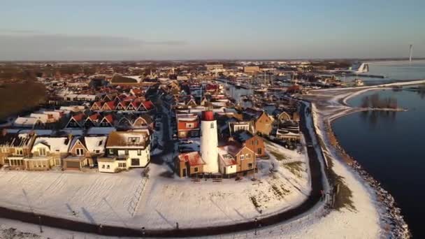 Urk Faro de los Países Bajos durante el invierno con la costa cubierta de nieve, vista de Urk en el faro nevado paisaje clima de invierno en Holanda — Vídeos de Stock