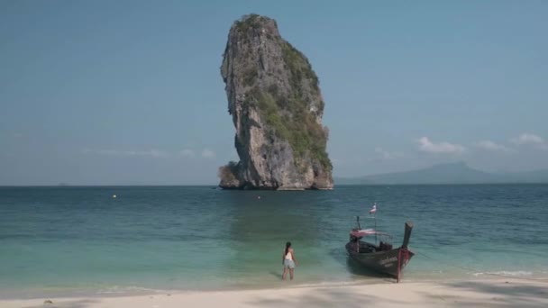 Azjatka w średnim wieku na tropikalnej plaży w Tajlandii, turysta spacerujący po białej tropikalnej plaży, Railay plaży z na tle lontail łodzi spadek od turysty — Wideo stockowe