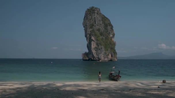 Asiatin mittleren Alters am tropischen Strand in Thailand, Touristin geht an einem weißen tropischen Strand spazieren, Railay-Strand mit Lontail-Boot im Hintergrund — Stockvideo