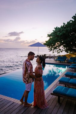 Curacao, Curacao 'da tatilde olan bir çift havuz kenarında gün batımını izliyor.