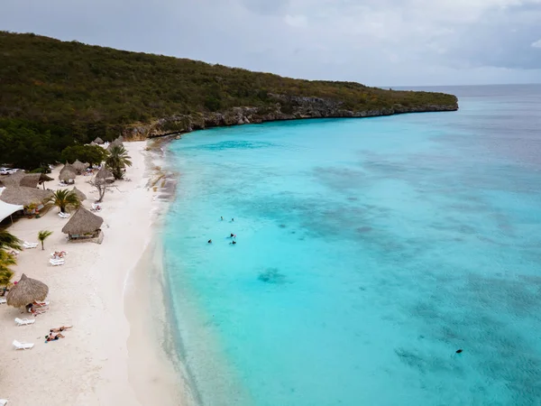 ビーチと桟橋- Curacaoのplaya Kalki 、ヤシの木があるビーチでの空のドローンビューからの熱帯ビーチ — ストック写真
