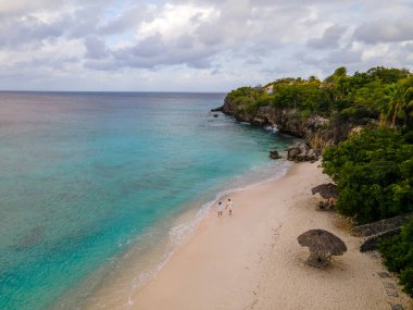 Curacao 'daki Playa Kalki' de plaj ve iskele, gökyüzünden gelen tropik plaj insansız hava aracı manzaralı palmiye ağacı olan plaj manzaralı.
