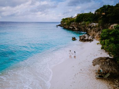 Curacao 'daki Playa Kalki' de plaj ve iskele, gökyüzünden gelen tropik plaj insansız hava aracı manzaralı palmiye ağacı olan plaj manzaralı.