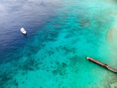 Curacao 'daki Playa Kalki' de plaj ve iskele, gökyüzünden gelen tropik plaj insansız hava aracı manzaralı palmiye ağacı olan plaj manzaralı.