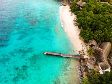 Curacao 'daki Playa Kalki' de plaj ve iskele, gökyüzünden gelen tropik plaj insansız hava aracı manzaralı palmiye ağacı olan plaj manzaralı.
