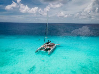 Küçük Curacao Adası, gündüz gezileriyle ve beyaz plajlarda yüzerek turlarla ve mavi berrak okyanusta, Karayip Denizi 'ndeki Klein Curacao Adası' nda