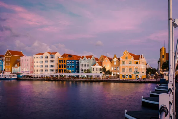 Curacao Willemstad, Sonnenuntergang in der farbenfrohen Stadt Willemstad mit Menschen, die an der Flottenbrücke spazieren gehen — Stockfoto