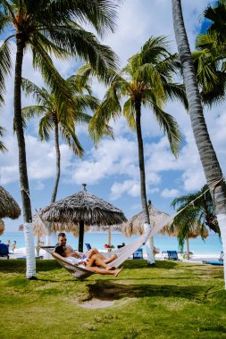 Palmiye ağaçlarıyla plajda Aruba Karayip Hamağı