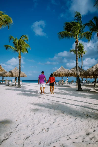 Palm Beach Aruba, Niesamowita tropikalna plaża z palmą wchodzącą do oceanu przed błękitnym oceanem, złotym piaskiem i błękitnym niebem — Zdjęcie stockowe