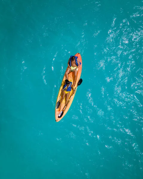 Pareja Kayak en el Océano en vacaciones Aruba Mar Caribe, hombre y mujer kayak de mediana edad en agua de la clrea azul océano — Foto de Stock