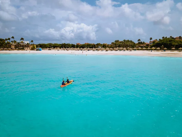 Para Kajakarstwo w oceanie na wakacjach Aruba Karaiby morze, mężczyzna i kobieta w średnim wieku kajak w oceanie niebieski klrea woda — Zdjęcie stockowe