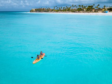 Okyanusta kayak yapan çift Aruba Karayip Denizi 'nde, orta yaşlı erkek ve kadın okyanus mavisi klrea suyunda kano.