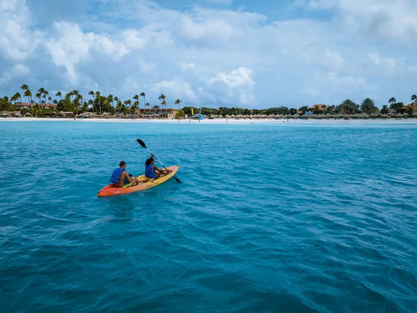 カップルカヤックで海で休暇アルバカリブ海、男と女中年齢カヤックで海青クレア水 — ストック写真