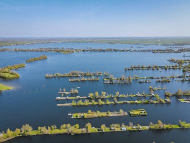 Hollanda, Vinkeveen yakınlarındaki Vinkeveense Plassen Gölü 'ndeki küçük adaların hava manzarası. Hollanda 'da dinlenmek için güzel bir doğa alanıdır.