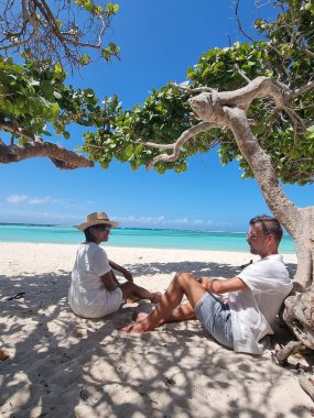 İnanılmaz Bebek Sahili ve Aruba, Karayipler kıyıları, mavi okyanus tropik plajlı beyaz plaj, kumsalda orta yaşlı çift dinleniyor.