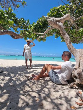 İnanılmaz Bebek Sahili ve Aruba, Karayipler kıyıları, mavi okyanus tropik plajlı beyaz plaj, kumsalda orta yaşlı çift dinleniyor.