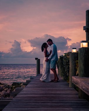 Günbatımında Curacao sahilinde bir çift, erkek ve kadın Curacao tropik plajında gün batımını izliyor.