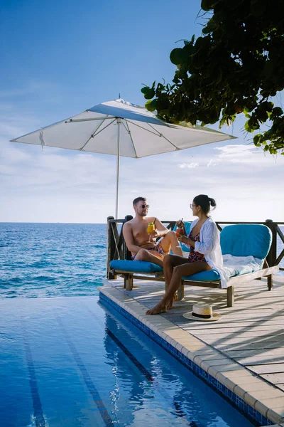 Curacao, tatilde yüzme havuzunda dinlenen erkek ve kadın, tatil sırasında Curacao 'da havuz başında dinlenen çift.