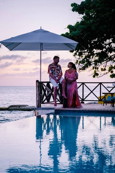 Curaçao, couple homme et femme d'âge moyen se relaxant au bord de la piscine pendant les vacances, hommes et filles au bord de la piscine à Curaçao pendant les vacances — Photo