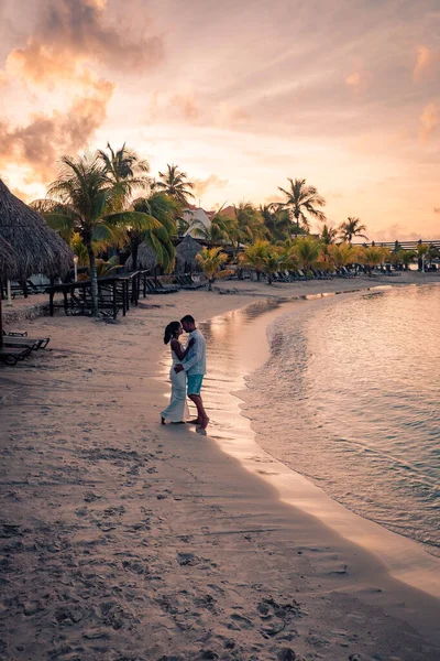 Günbatımında Curacao sahilinde bir çift, erkek ve kadın Curacao tropik plajında gün batımını izliyor. — Stok fotoğraf