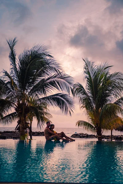 Casal na praia de Curaçao durante o pôr do sol, homens e mulheres assistindo ao pôr do sol na praia tropical de Curaçao — Fotografia de Stock