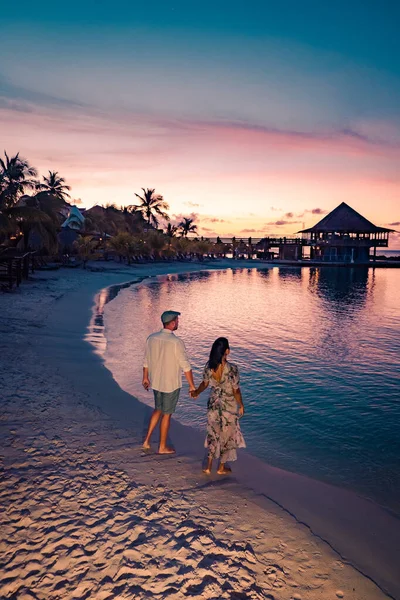 Couple sur la plage de Curaçao au coucher du soleil, hommes et femmes regardant le coucher du soleil sur la plage tropicale de Curaçao — Photo