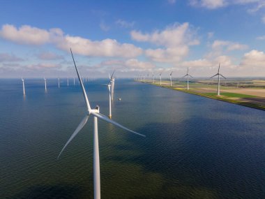 Bulutları ve mavi gökyüzü olan off-shore yel değirmeni parkı, okyanus drone parkı rüzgar türbini Flevoland Hollanda Ijsselmeer ile hava manzaralı