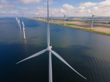 Bulutları ve mavi gökyüzü olan off-shore yel değirmeni parkı, okyanus drone parkı rüzgar türbini Flevoland Hollanda Ijsselmeer ile hava manzaralı