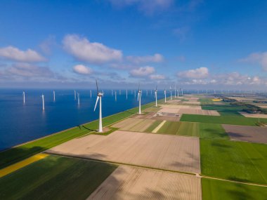 Bulutları ve mavi gökyüzü olan off-shore yel değirmeni parkı, okyanus drone parkı rüzgar türbini Flevoland Hollanda Ijsselmeer ile hava manzaralı