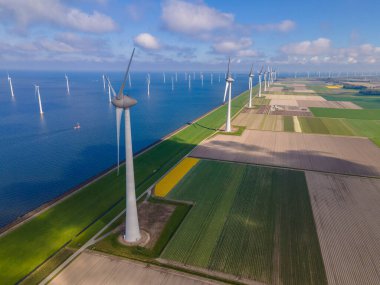 Bulutları ve mavi gökyüzü olan off-shore yel değirmeni parkı, okyanus drone parkı rüzgar türbini Flevoland Hollanda Ijsselmeer ile hava manzaralı