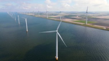 Bulutları ve mavi gökyüzü olan off-shore yel değirmeni parkı, okyanus drone parkı rüzgar türbini Flevoland Hollanda Ijsselmeer ile hava manzaralı