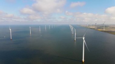 Bulutları ve mavi gökyüzü olan off-shore yel değirmeni parkı, okyanus drone parkı rüzgar türbini Flevoland Hollanda Ijsselmeer ile hava manzaralı