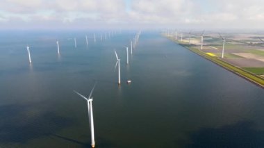 Bulutları ve mavi gökyüzü olan off-shore yel değirmeni parkı, okyanus drone parkı rüzgar türbini Flevoland Hollanda Ijsselmeer ile hava manzaralı