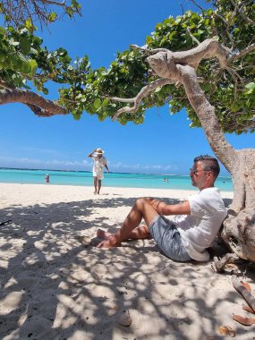 İnanılmaz Bebek Sahili ve Aruba, Karayipler kıyıları, mavi okyanus tropik plajlı beyaz plaj, kumsalda orta yaşlı çift dinleniyor.
