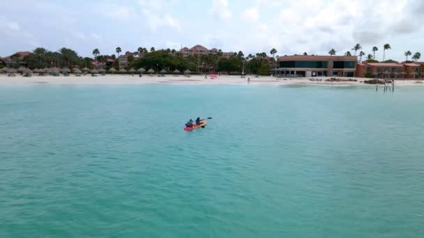 Paar Kajakfahren im Ozean auf Urlaub auf Aruba Karibik, Mann und Frau mittleren Alters Kajak im Ozean blau clrea Wasser — Stockvideo