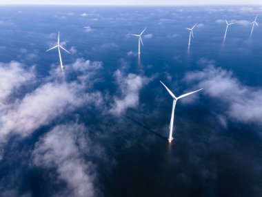 Bulutları ve mavi gökyüzü olan off-shore yel değirmeni parkı, okyanus drone parkı rüzgar türbini Flevoland Hollanda Ijsselmeer ile hava manzaralı