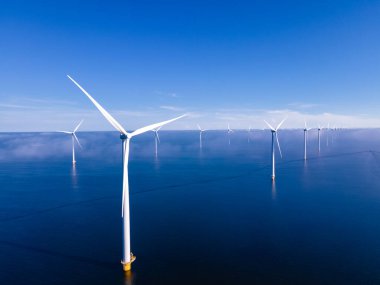 Bulutları ve mavi gökyüzü olan off-shore yel değirmeni parkı, okyanus drone parkı rüzgar türbini Flevoland Hollanda Ijsselmeer ile hava manzaralı