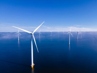 Bulutları ve mavi gökyüzü olan off-shore yel değirmeni parkı, okyanus drone parkı rüzgar türbini Flevoland Hollanda Ijsselmeer ile hava manzaralı